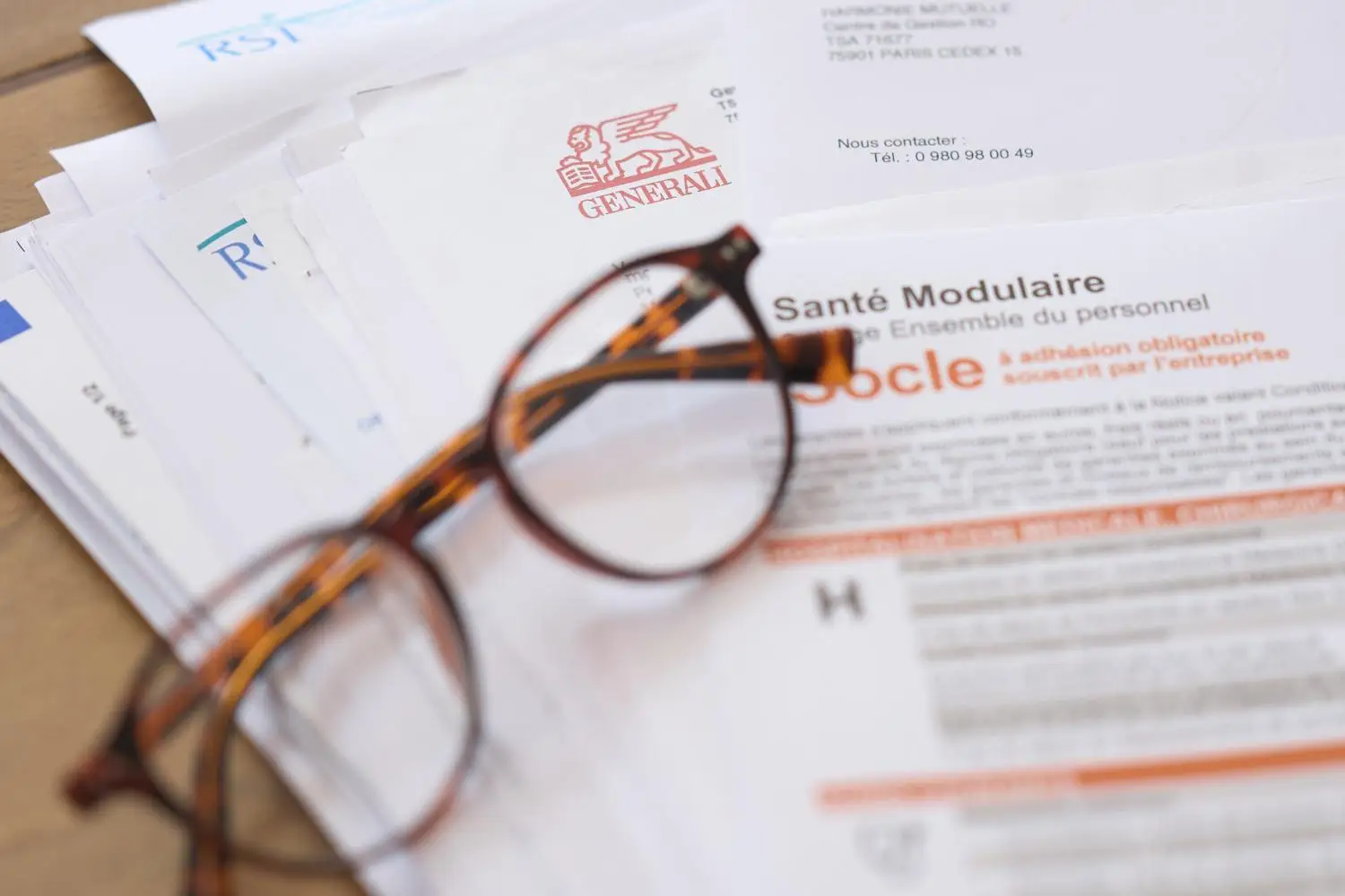 une paire de lunettes devant des dossiers de démarches administratives